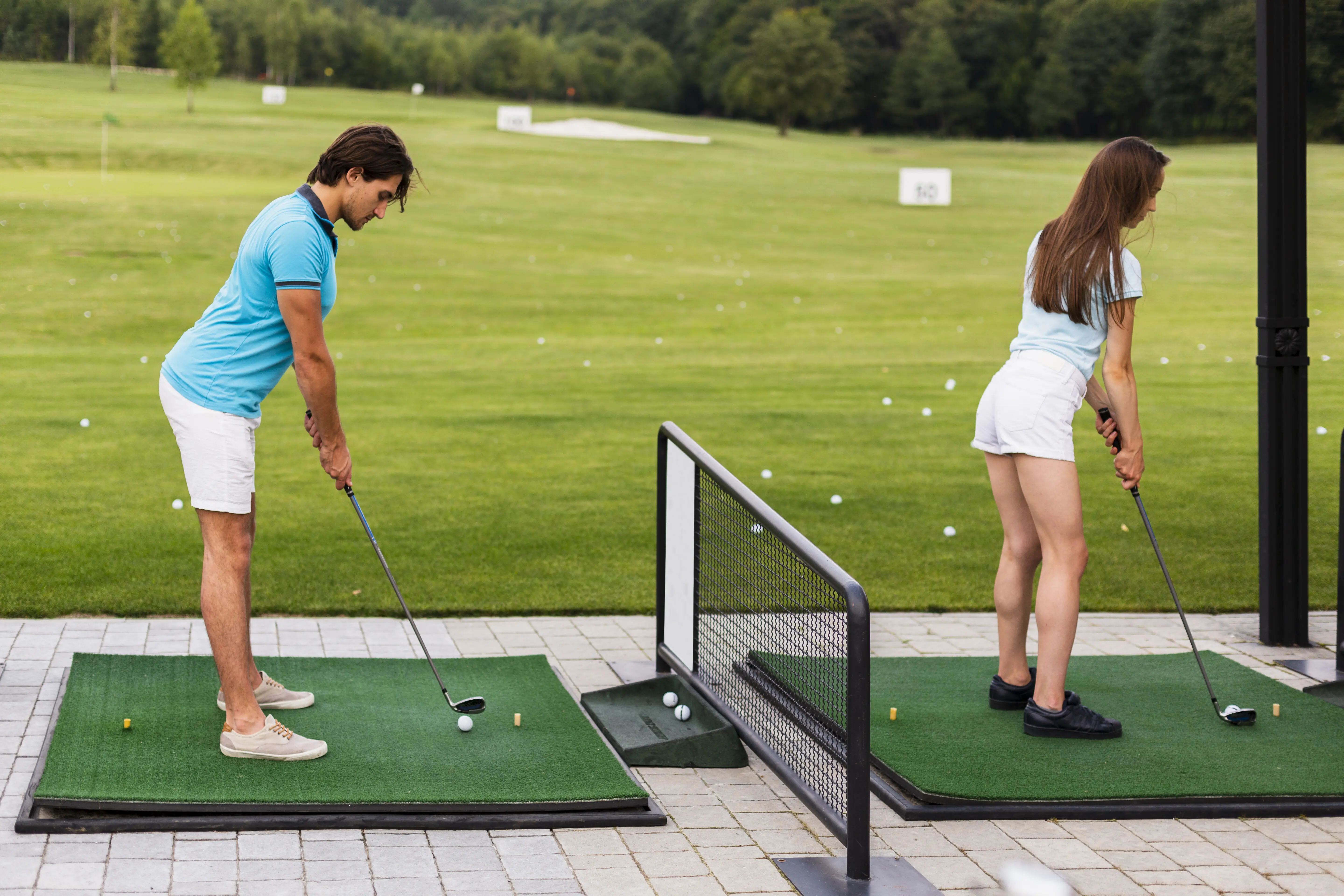 Rear view of golfers practicing their swings